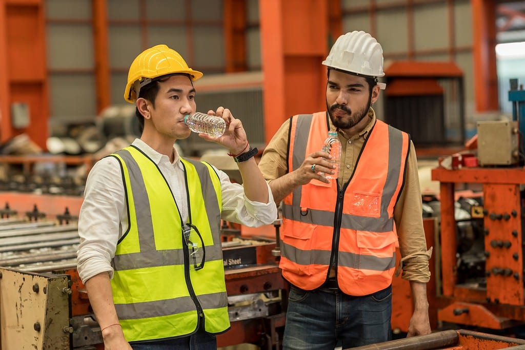 Worker drinking water in factory site.